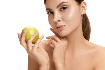 Obraz na płótnie Canvas The portrait of attractive caucasian smiling woman isolated on white studio background with green apple fruits. The beauty, care, skin, treatment, health, spa, cosmetic and advertising concept