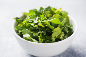 Chopped parsley leaves in a plate. Close up