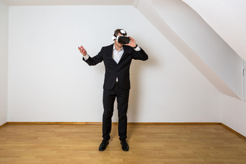 Mann mit aufgesetzter VR Brille steht fragend im leeren, weißen Raum