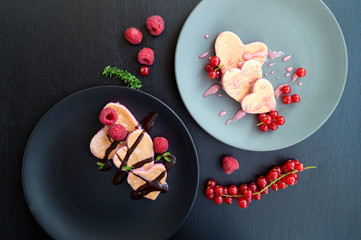 Obraz na płótnie Canvas Heart shaped pancakes with currant for Valentine's day