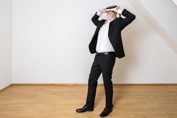 Mann mit VR Brille bewegt sich dynamisch im leeren Raum. Er testet seine virtuelle Einrichtung.