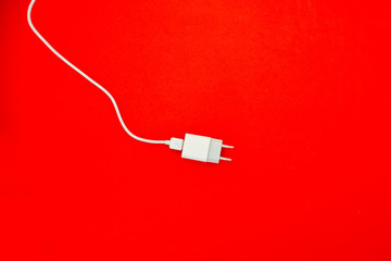 Fototapeta premium Charger through USB Cable on Turquoise Background Top View