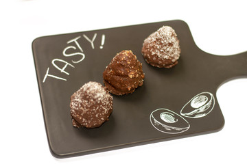 Three chocolate cookies served on the black tray
