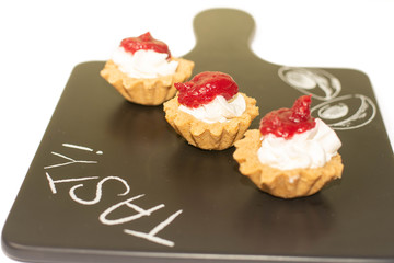 Three cheese cakes with raspberry dressing on the top