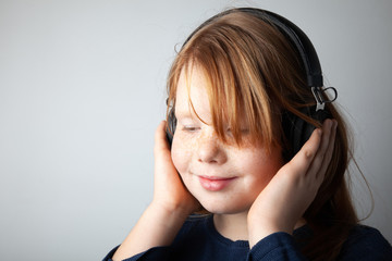 Fototapeta premium Pretty fat girl listening to music in delight. Fascinated by the song.