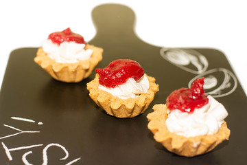 Three cheese cakes with raspberry dressing on the top