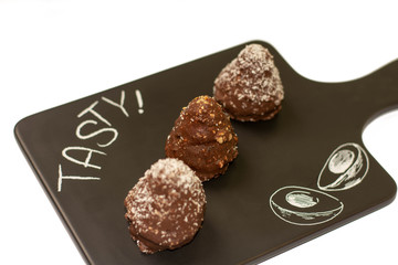 Three chocolate cookies served on the black tray