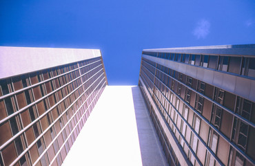 Vintage photo circa 1960s, skyscraper in Sydney Australia. Viewed from below looking up to blue...
