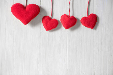 rows of red heart hanging on white wood wall background