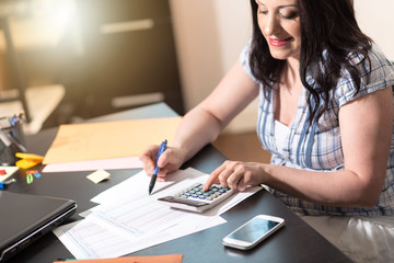 Obraz na płótnie Canvas Female accountant using calculator