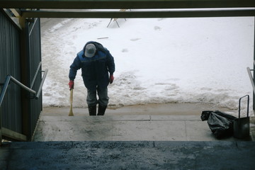worker sweeps up trash and snow in transition