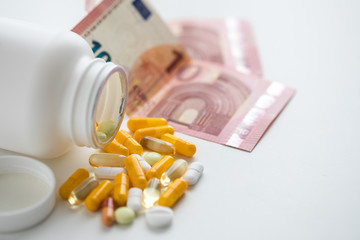 Geld für Drogen Doping Leistungssteigerung Pillendose mit gelben und weißen Pillen Kapseln und Tabletten