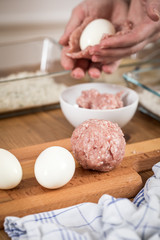 Frau kocht Scotch Eggs, Eier in Schweine Fleisch Wurstbrät und Paniermehl 