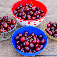 Berries of a sweet cherry on a wooden background in a plastic cu