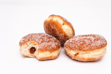 Obraz na płótnie Canvas Traditional German or Austrian fried donuts with no hole, so called Krapfen, Berliner or Pfannkuchen with cinnamon sugar and filled with rose hip, raspberry or strawberry jam, party or carnival food