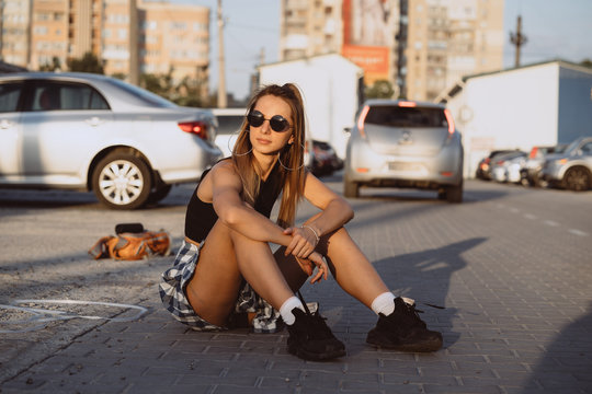 Portrait of young stylish woman posing in parking