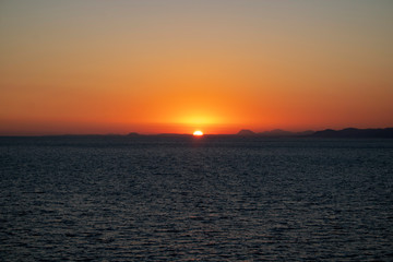 Beautiful morning sunrise over the sea showing yellow sun with a few clouds in the background, taken in Spain Costa Brava near Alicante and Benidorm 