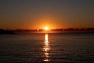 Beautiful morning sunrise over the sea showing yellow sun with a few clouds in the background, taken in Spain Costa Brava near Alicante and Benidorm 