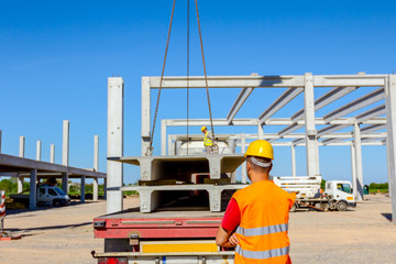 Naklejka premium Boss oversees, control unloading concrete joist in truck trailer