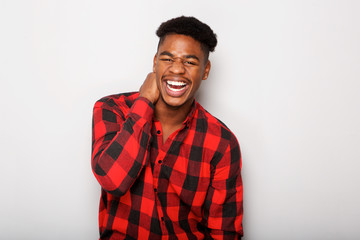 cheerful young African american man laughing against gray background