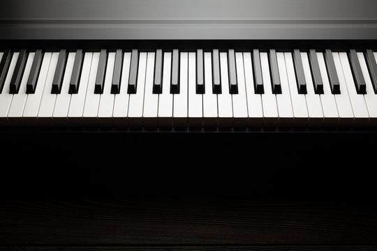 Piano keyboard on dark wooden table