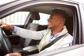 charming young african american man driving car in the city