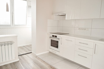 Luxury modern kitchen in new apartment. New white kitchen with appliances and beautiful interior. Elegance of style.