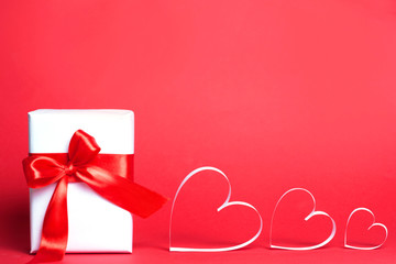 Gift box with hearts on red background. Top view, flat lay. St. Valentine's day greetind concept.