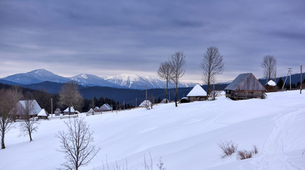 Panoramic view of idyllic winter mountain tops and traditional mountain huts in the Carpathians