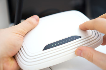 Man holding white wireless router in his hands.