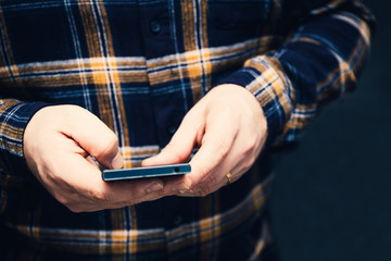 hipster man holding smartphone and tapping on the screen