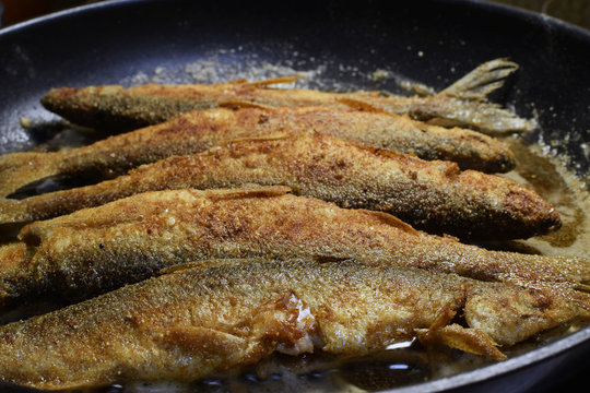 Vendace fishes frying on pan. 