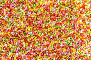 Close-up of colorful little stars made of sugar to decorate desserts, culinary background.