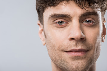 Obraz premium portrait of handsome young smiling man isolated on grey