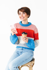 Happy cheerful girl wearing sweater sitting on a chair