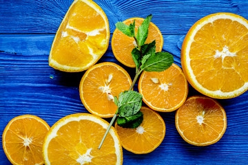 homemade orange smoothie making on blue wooden table top view