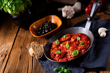 Baked mini meatballs in tomato sauce with basil