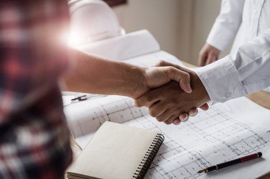 construction worker team hands shaking after consultation meeting to greeting start up plan new project contract in office center at construction site, teamwork, partnership and contractor concept - Powered by Adobe