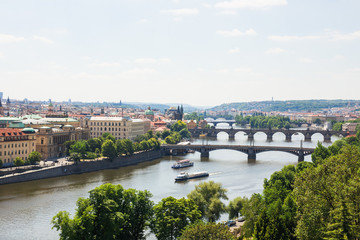 Fototapeta na wymiar Scenic view of bridges on the Vltava river and of the historical center of Prague: buildings and landmarks of old town with red rooftops