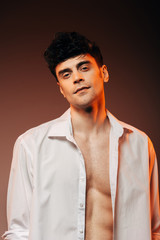 fashionable sexy man posing in white shirt, isolated on brown