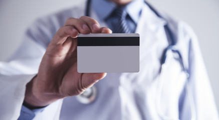Doctor holding credit card.