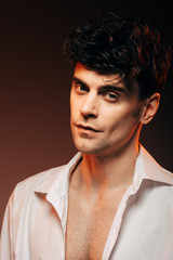 Fototapeta premium handsome man posing in white shirt, isolated on brown