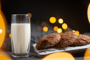 A glass of milk and chocolate cookies, with beautiful lights and Concept, copy Space