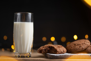 A glass of milk and chocolate cookies with beautiful lights