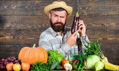 Farmer with organic vegetables. Excellent quality harvest. Grow organic crops. Organic fertilizers make soil and plants healthy and strong. Organic pest control. Man with beard wooden background