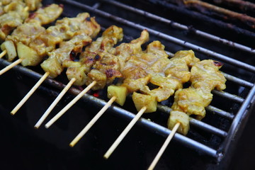 Grillled barbecue pork satay skewers on charcoal grill stove in street food market. Pork. Grilled spices pork on Charcoal stove 