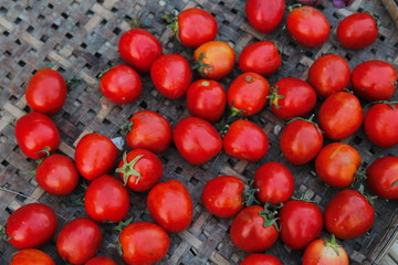 Ripe red tomato on bamboo weave. Ingredient background. Kitchen cooking concept