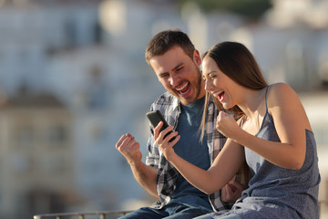 Excited couple or friends reading phone content