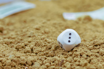 dice with a number one, lost in the sand