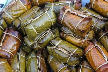 Thai street food, Thai desserts. Sticky rice cakes bundle wrapped banana leaves The name is Khao Tom Mat at Fresh market in Thailand